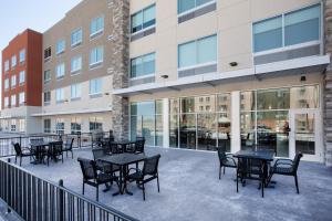a patio with tables and chairs in front of a building at Holiday Inn Express & Suites - Denver NE - Brighton, an IHG Hotel in Brighton