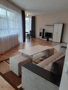 una sala de estar con un sofá y una mesa en АПАРТАМЕНТ Амира 2, en Balchik