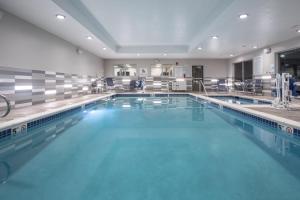 a large swimming pool with blue water at Holiday Inn Express & Suites - Denver NE - Brighton, an IHG Hotel in Brighton