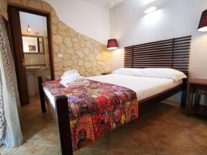 a bedroom with a bed and a table with a phone on it at Del Centro in Enna