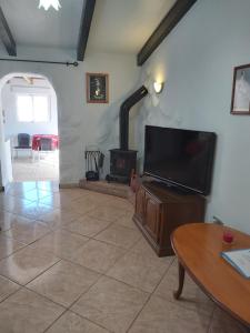 a living room with a flat screen tv and a fireplace at Casa con Vistas in Serón