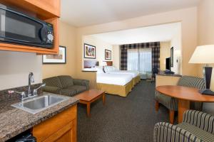 a hotel room with a bed and a kitchen with a sink at Holiday Inn Express Hotel Vernal by IHG in Vernal