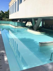 a swimming pool with blue water in front of a building at Águas do Paranoá in Caldas Novas