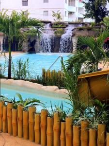 a swimming pool with a waterfall next to a building at Águas do Paranoá in Caldas Novas