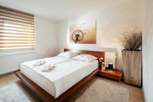 Un dormitorio con una gran cama blanca y una ventana en Apartments in Villa Olimp, en Liubliana