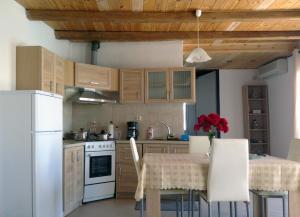 馬塔拉的住宿－Matala Blue，厨房配有木制橱柜和红色鲜花桌