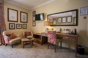 a room with a desk and a mirror and a chair at The Castle Hotel, Conwy, North Wales - The Coaching Inn Group in Conwy