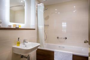 a bathroom with a sink and a shower and a tub at The Castle Hotel, Conwy, North Wales - The Coaching Inn Group in Conwy