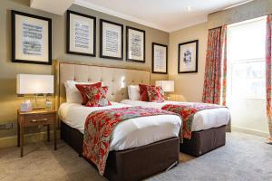 a bedroom with two beds and a window and two lamps at The Castle Hotel, Conwy, North Wales - The Coaching Inn Group in Conwy
