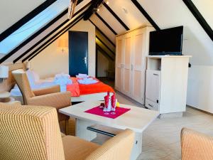 a living room with a bed and a tv at Aparthotel Kleine Perle in Cuxhaven