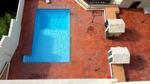 a blue swimming pool on a brick building at Lila Ocean View Apartment in Ponta Delgada