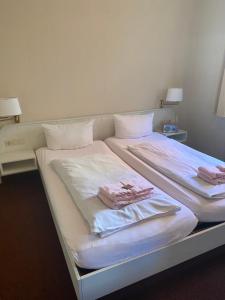 a large white bed with two folded towels on it at Ferienhaus Zunftstuben in Norderney