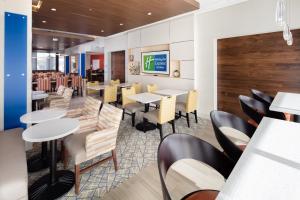 une salle à manger avec des tables et des chaises dans un restaurant dans l'établissement Holiday Inn Express East Peoria - Riverfront, an IHG Hotel, à Peoria