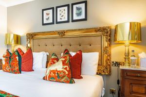 a bedroom with a bed with pillows and two lamps at The Castle Hotel, Conwy, North Wales - The Coaching Inn Group in Conwy