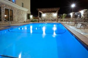 uma piscina à noite com iluminação azul em Holiday Inn Express Texas City, an IHG Hotel em Texas City
