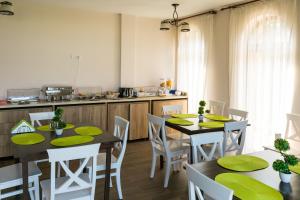 a kitchen with two tables and chairs with green napkins at Villa Ciao - Adults Only in Corbu