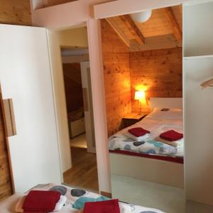 ein kleines Zimmer mit einem Bett und einem Spiegel in der Unterkunft Chalet Safran in Grächen