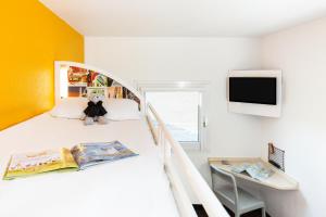 um quarto com uma cama com um urso de peluche em HôtelF1 Angoulême em Champniers