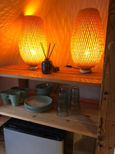 two lights sitting on top of a shelf with dishes at B&B De Pauw - Country Home Cooking in Graft