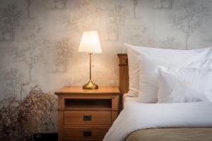 a bed with a table with a lamp on it at Monastery Garden Prague in Prague