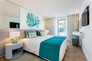 ein Schlafzimmer mit einem großen Bett und einem TV in der Unterkunft Quinta do Lago Country Club in Quinta do Lago