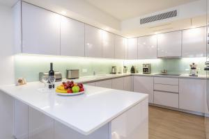 a white kitchen with a plate of fruit on a counter at Quinta do Lago Country Club in Quinta do Lago