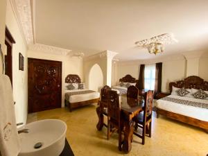 ein Badezimmer mit einem Schlafzimmer mit Tisch und Bett in der Unterkunft Hotel Royal Puebla in Puebla