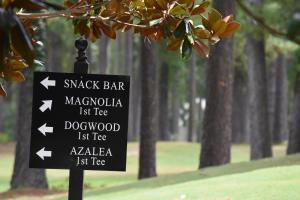 un panneau dans un parc avec des arbres en arrière-plan dans l'établissement Family Condo 1504M with Golf Course, à Calabash