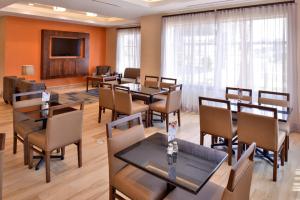 une salle de conférence avec des tables, des chaises et une télévision dans l'établissement Holiday Inn Express Hotels & Suites Loma Linda, an IHG Hotel, à Loma Linda