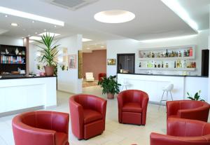 a waiting room with red chairs and a bar at Hotel 660 in Bisignano