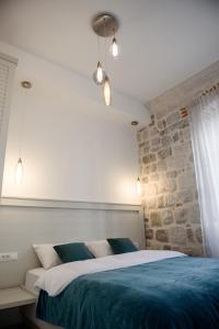 コトルにあるPalazzo Sindikの石壁のベッドルーム1室(大型ベッド1台付)