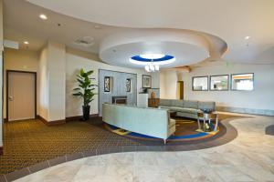 een lobby met een bank en een tafel bij Holiday Inn Express and Suites Denver East Peoria Street, an IHG Hotel in Denver