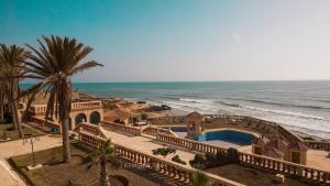 une maison avec une piscine à côté de l'océan dans l'établissement Umbrella Holidays l 1Bd room l, à Dcheïra