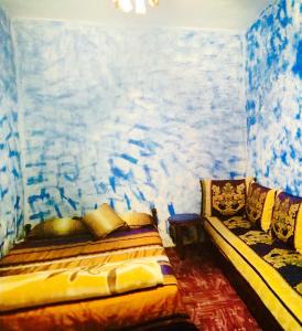 a bedroom with a bed and a painting on the wall at casa malek in Chefchaouene