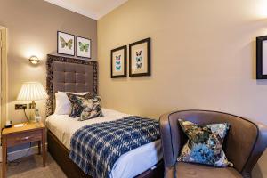a bedroom with a bed and a chair at The Castle Hotel, Conwy, North Wales - The Coaching Inn Group in Conwy