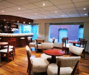 Un restaurante con mesas y sillas y un bar. en Gran Hotel Ambassador, en Cochabamba