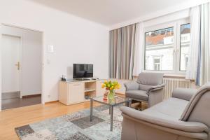 un soggiorno con divano, sedie e TV di Appartements Ferchergasse a Vienna