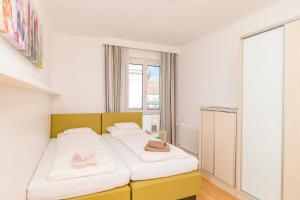 una camera da letto con un letto e due pantofole sopra di Appartements Ferchergasse a Vienna
