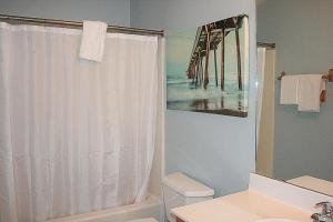 een badkamer met een douchegordijn en een wastafel bij 104M condo in Calabash