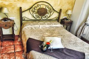 Casa Rural el Herrero de Pollos في Pollos: غرفة نوم بسرير على اللوح الأمامي وطاولتين