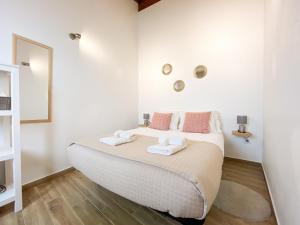 a bedroom with a large bed with two towels on it at Casa do Sapateiro - No centro histórico de Aljezur in Aljezur