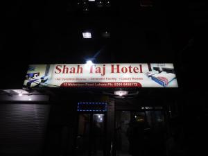 Shah Taj Hotel في لاهور: علامة على فندق shah la في الليل