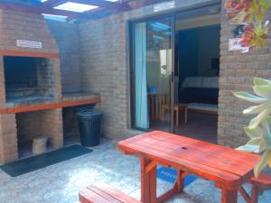 ceglane patio z drewnianą ławką i kominkiem w obiekcie Thornbay accommodation w mieście Doring Bay