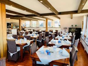 a restaurant with tables and chairs in a room at Aparthotel Kleine Perle in Cuxhaven
