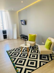 een woonkamer met 2 stoelen en een tapijt bij Urban Apart - Azores in Ponta Delgada