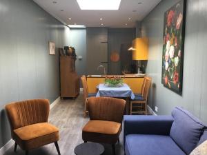 une salle à manger avec une table et un canapé bleu dans l'établissement B&B Alkmaars Toppunt XL, à Alkmaar