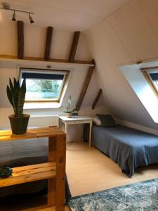 a attic bedroom with a bed and a desk at B&B De Pauw - Country Home Cooking in Graft