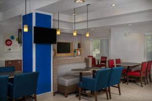 a restaurant with tables and chairs and a tv at Holiday Inn Express Independence - Kansas City, an IHG Hotel in Independence