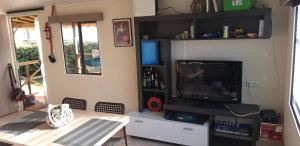 een woonkamer met een tv en een tafel met een tafel bij SIBLU CONDRIEU in Condrieu