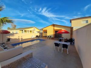 a patio with a table and chairs and a pool at Caseta De L'avi in Camarles